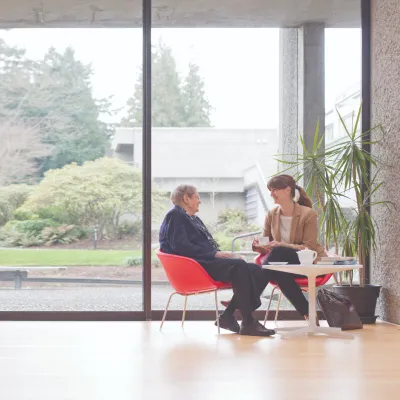 Woman having a conversation with an elderly woman by the window